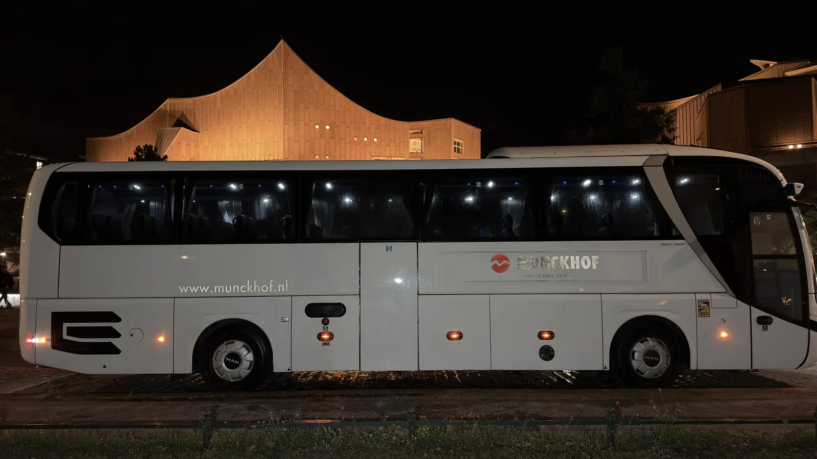 Weiße Busseitenwand nach der Graffitientfernung mit wieder sichtbarer Fahrzeugbeschriftung