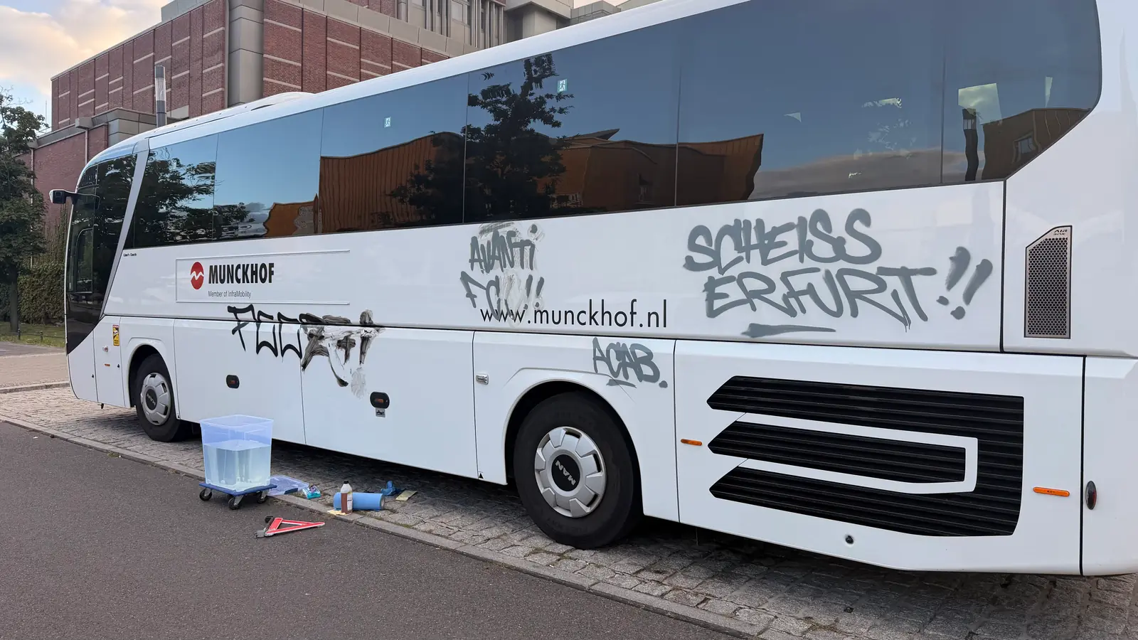 Begonnene Graffitientfernung an der weißen Seitenwand eines Reisebusses