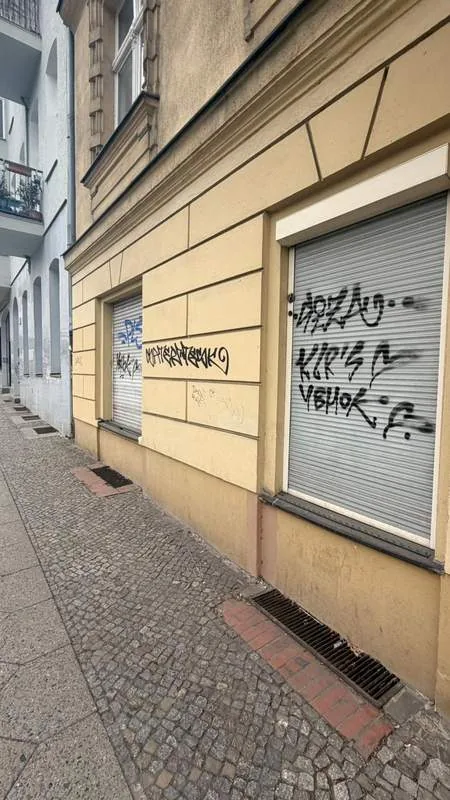 Graffiti auf Rollladen und Fassadenteilen vor der Reinigung in Berlin-Mitte